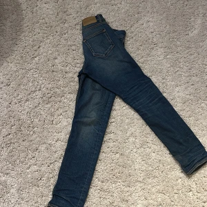 Tiger of Sweden  jeans blå - Snygga tiger of sweden jeans i klassisk blå tvätt med skinny fit. Jeansen har fem fickor, läderpatch bak och subtila slitningar för en cool look. Perfekta för dig som gillar en smal siluett och tidlös denimstil.