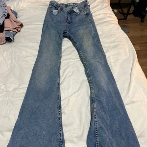Blå flare jeans från 157, storlek S - Säljer ett par snygga blå flare jeans från 157 i modellen Snake Flare. Jeansen har klassisk femficksdesign, normal midja och utsvängda ben. Tillverkade i mjukt denimtyg som sitter skönt hela dagen. Perfekta för dig som gillar retrovibbar och vill sticka ut.