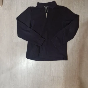 Mörkblå half zip tröja H&M XS - Mörkblå långärmad tröja från H&M i storlek XS. Tröjan har en klassisk krage och en snygg half zip-dragkedja framtill. Perfekt för lager-på-lager och chill stil. Mjuk och skön, passar till jeans.