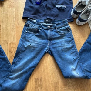 Blå Replay Anbass Jeans Med Slitningar  - Säljer ett par blå jeans från Replay med coola slitningar och distressed detaljer på både fram- och baksida. Klassisk femficksmodell med raka ben och snygga sömmar på bakfickorna. Jeansen har normal passform och är gjorda i mjukt denimtyg. Skick: 9/10.  Modell: Anbass. Färg: Blå/Mörkblå.  Riktig Feta jeans, hör ev er vid funderingar!