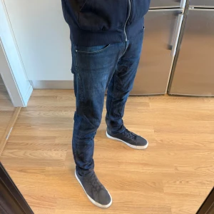 Tiger of Sweden Pistolero Jeans Marinblå W31 L34 - Sjukt fina Tiger of Sweden Pistolero jeans i en marinblå färg i storlek W31/L34. Mått - Midja: 40cm Benlängd: 107cm. Modellen är ca 184cm & 63kg. Hör av dig vid funderingar!🤩