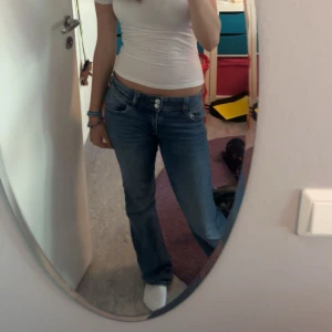 Blå bootcut jeans låg midja - Säljer ett par klassiska blå jeans med bootcut och låg midja. Jeansen har en snygg tvätt och sitter skönt på höften. Perfekta för dig som gillar en avslappnad men trendig look. Två fickor där bak. Storlek 164 men passar som Xs 