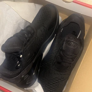 Nike Air Max 270 Triple Black sneakers - Helt  nya/oanvända Nike Air Max 270 Triple Black sneakers med en clean helsvart look. Ovandel i mesh och syntet, stor synlig Air-enhet i hälen och diskret Nike-logga på sidan. Skorna har snörning och en sportig vibe som passar perfekt till streetwear. 