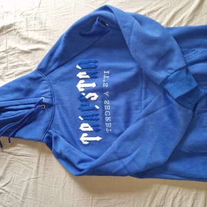 Blå Trapstar hoodie - Snygg blå trapstar hooide. Tröjan har huva med snörning och en klassisk känguruficka framtill. Använd 1-2 gånger endast.
