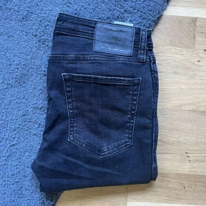 Jack & Jones jeans - Svarta skinny jeans från Jack & Jones, modell Spray On Tom. Jeansen har klassisk femficksdesign, smal passform och är tillverkade i stretchigt bomullsmaterial för extra komfort. Perfekta för dig som gillar en tajt look. Midja 38cm Jag skickar ej bild när jag bär plaggen och jag vet ej vilken längd och vikt de passar då jag inte prövar kläderna jag säljer 😃