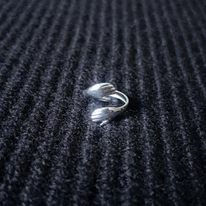 Câlin d’Argent – Silver Hug Ring - Justerbar ring i rostfritt stål, rost- och nickelfri. Två armar och händer sveper mjukt runt fingret i en omfamnande design som känns både varm och unik.