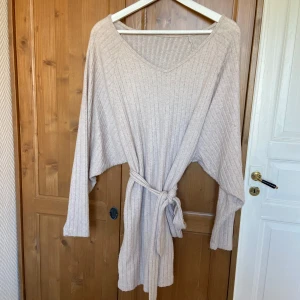 Bekväm klänning - Så mysigt tyg! Använt skick, är nopprig som ni ser på bild 4 och som ni ser på bild 3 har tråden man fäster bandet i lossnat men man kan ju knyta bandet ändå även utan det sitter fast i klänning sådär. Därav pris. Men annars fin och använt den ändå! Vet ej storlek men tror xs-s.  Skriv om du vill köpa annat på min sida så kan du få paketpris och slippa betala dubbelfrakt.