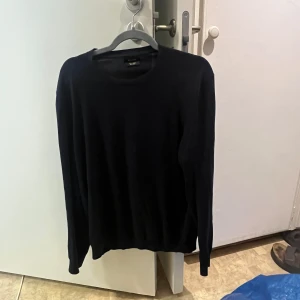 Mörkblå stickad tröja Massimo Dutti - En klassisk mörkblå stickad tröja från Massimo Dutti i storlek M. Tröjan har rund halsringning och långa ärmar, perfekt för lager-på-lager. Enkel och stilren design som funkar till allt. Materialet är mjukt och skönt mot huden.