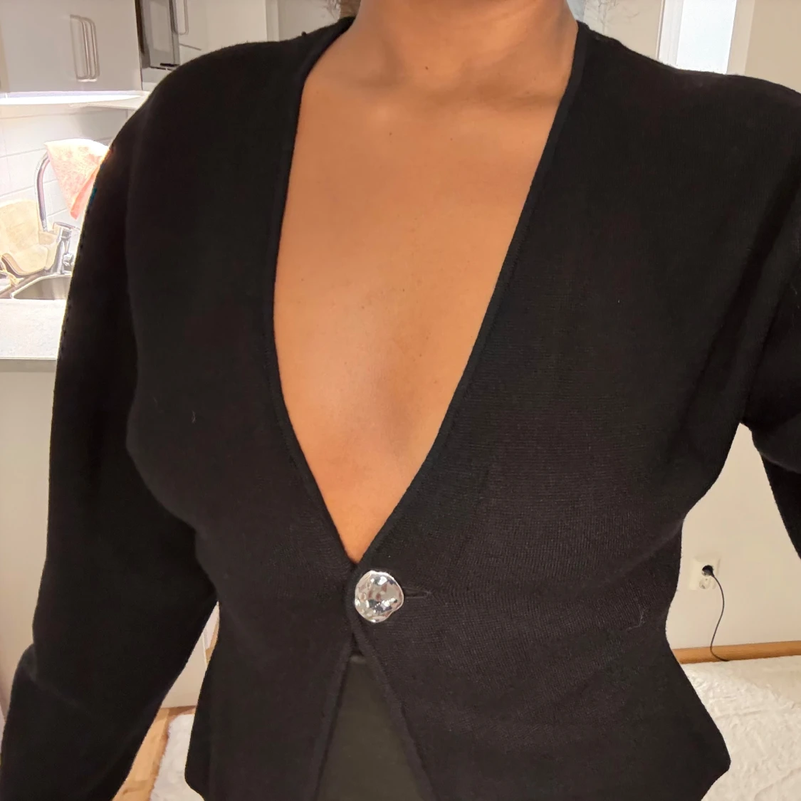 Svart kofta med djup v-ringning