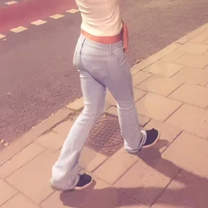 Ljusblå bootcut jeans med slitningar - Säljer ett par ljusblå jeans med bootcut passform och snygga slitningar över knäna. Jeansen har låg midja och är tillverkade i klassiskt denimtyg. Perfekta för dig som gillar en avslappnad och trendig look.