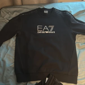Svart EA7 Emporio Armani tracksuit - Det är en jätte snygg Armani tracksuit som jag har aldrig använt för att jag föredrar luvor. Det är L på båda men dem passar M också!