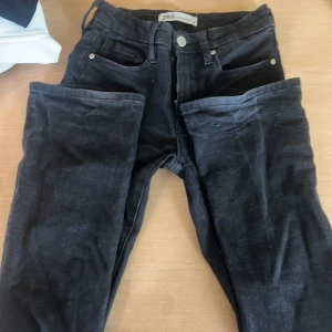 Svarta lågmidjade jeans från Zara - Snygga svarta jeans från Zara med klassisk femficksdesign. Byxorna har lågmidja och är bootcut. Perfekta för dig som gillar stilrena och bekväma jeans, säljer pågrund av för små.