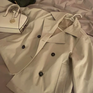 Beige trenchcoat - Beige trenchcoat som används i fåtal tillfällen, helt ren och inga tecken på användning 