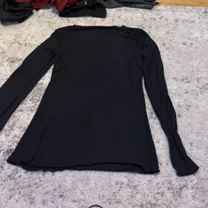 Intimissimi  uringad svart tröja Small - En svart långärmad topp med enkel och stilren design. Tunt, stretchigt material som sitter skönt mot kroppen. Perfekt att styla med jeans eller kjol för en clean look. Rund halsringning och smal passform. Inte använd 