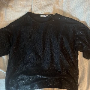Glittrig och skimrig t-shirt från Kappahl - Säljer nu min fest topp ifrån Kappahl, den är både glittrig och skimrig och perfekt till festligheter!💕💕 Den är i storlek XS men har en avslappnad passform och breda ärmar, använd en gång🥰