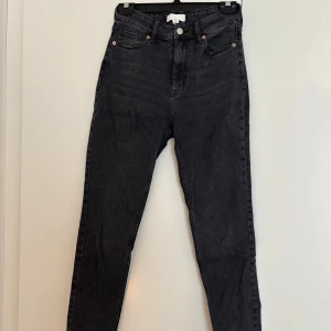 Svarta skinny jeans från H&M, strl 36 - Snygga svarta skinny jeans från H&M i storlek 36. Hög midja och klassisk femficksmodell med dragkedja och knapp framtill. Jeansen har en mörk tvätt och är tillverkade i stretchig bomullsdenim för en tight passform. Aldrig använda.