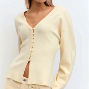 Beige kofta med knappar och v-ringning - Säljer en stilren beige kofta med v-ringning och dekorativa knappar framtill. Använd en gång, köpt på gina.