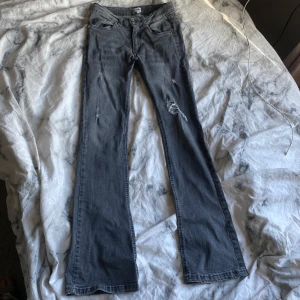 Grå/svart bootcut jeans  - Säljer ett par grå/svart bootcut jeans från RIVALS med coola slitningar 😍jättebra skick! strl 158/164