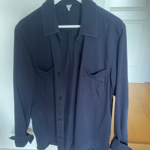 Mörkblå overshirt med fickor - Säljer en stilren mörkblå overshirt med två bröstfickor och klassisk krage. Overshirten har långa ärmar och knäppning framtill. Otroligt bekväm och helt perfekt till sommaren! Den är i storleken 48, och nassar mig perfekt som är 187, men passar även dig mellan 180-195! Köpt på arket för ungefär lite under 1000 kr, mitt pris 299! Hör av er vid minsta fundering!