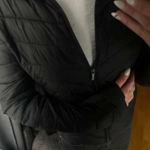 Svart pufferjacka från Primark - Säljer en svart pufferjacka från Primark i storlek XS. Jackan har lång ärm, dragkedja framtill och är lätt vadderad för extra värme. Perfekt för kyligare dagar och enkel att matcha med olika outfits.