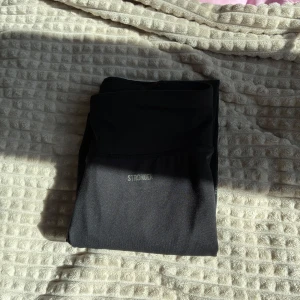 Svarta tights från Stronger - Säljer ett par svarta tights från Stronger. De är långa och har en tight passform, perfekta för träning eller vardagsaktiviteter. Materialet är stretchigt och bekvämt, tillverkat i polyester och elastan.