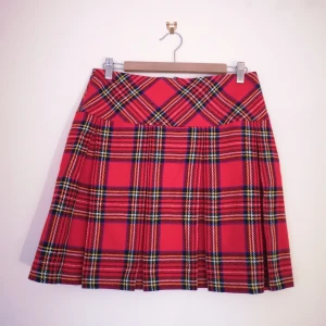 Rutig kjol - strl 38 - Rutig kjol i rött, gult, grönt, svart och vitt. Hög midja, ingen stretch, dragkedja bak. Mått - 72cm i midjan, 46cm lång. Kan fixa fler bilder vid intresse! 