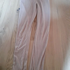 Beige leggings från H&M - Säljer ett par beige leggings från H&M i mjukt och stretchigt material. De har en tight passform och är perfekta för en avslappnad stil. Materialet består av 86% polyester och 14% elastan. De ser ut som fejk mocka. Bara testade pågrund av för stora