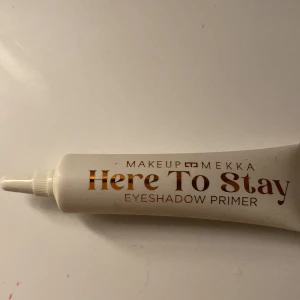 Here To Stay Eyeshadow Primer - Ögonskuggsprimer från Makeup Mekka i en vit tub med guldbrun text. Perfekt för att få ögonskuggan att sitta längre och ge intensivare färg. Enkel att applicera tack vare smal spets. Aldrig använd.