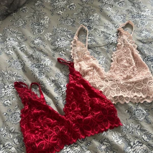 Två-pack bralettes - Säljer två snygga bralettes i spets, Båda har djup v-ringning och tunna axelband. Perfekta att bära under en skjorta eller som de är för en trendig look. Står M på dom men skulle säga S