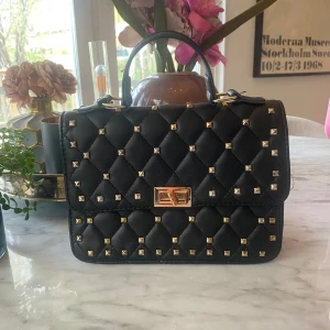 Svart nitväska  - Svart väska med nitar. Knäppet är trasigt men går fortdrande att stänga och öppna har också gått upp lite trådar på bandet ( se bilderna för defekter)  därav priset. Går säker att laga men är inte så pysslig av mig 🩷