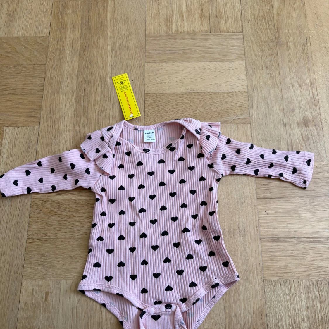 Rosa ribbad body med svarta hjärtan 