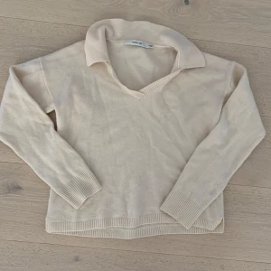 Kashmirtröja - Säljer en beige stickad tröja från Gestuz med v-ringning och klassisk krage. Blandmaterial.