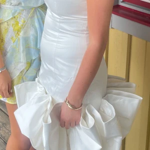 Rotate Birger Christensen  - Vit drömklänning – använd en gång!  Säljer denna fantastiska vita klänning med unika detaljer i nederdelen. Den är figursydd med smala axelband och ett riktigt statement-plagg till exempelvis student, fest eller bal. Endast använd en gång – i princip nyskick! Säljes då den tyvärr är för liten för mig. I’m  (Är 156 cm men funkar på längre bara att den blir kortare) Storlek: s Nypris: 4500:- Pris: 2800:-  Skicka ett meddelande vid intresse eller om du vill ha fler bilder!