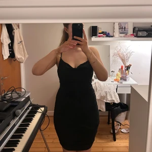 Svart tight klänning med smala axelband från Zara - Säljer en svart tight klänning från Zara med smala korsade axelband och figurnära passform. Klänningen är kort och har en enkel, stilren design som passar perfekt till olika tillfällen men speciellt fester. Materialet är mjukt och stretchigt. Endast använd 1 gång!