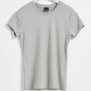 Iron (7032) färgad tjat T-shirt från Gina - En tajt T-shirt som ger en fin form i färgen Iron från Gina Tricot. Den är i super bra kondition + helt oanvänd. 