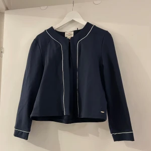 Kofta med vita detaljer - Snygg mörkblå kofta med vita detaljer. 