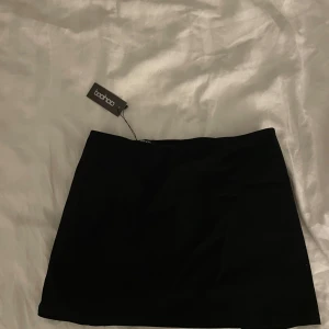 Svart minikjol  - Säljer denna oandvända low rise mini kjolen från Boohoo