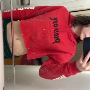 Röd hoodie från H&M x Justin Bieber - Säljer en röd croppad hoodie från H&M:s Justin Bieber-kollektion. Tröjan har tryck på bröstet och ärmarna, huva med dragsko och mjukt material på insidan. Perfekt för dig som vill ha en statement-piece i garderoben!