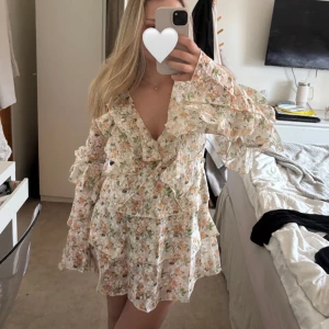 Blommig volangklänning från PrettyLittleThing - Supersöt kort blommig klänning från PrettyLittleThing med volanger och v-ringning. Den är helt ny och säljer då storleken ej passa mig.💕Perfekt för vår och sommar!🥰