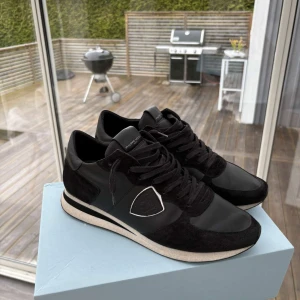 Svarta sneakers från Philippe Model - Snygga svarta sneakers från Philippe Model med vita detaljer och svart snörning. Skorna har en kombination av skinn och mocka. Använda ett antal gånger🔵 kom privat vid minst funderingar och frågor
