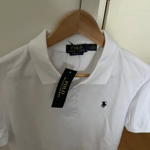 Vit piké Polo Ralph Lauren - Aldrig använd 10/10 med prislapp på. Storleken är L men Skulle säga det är en slim fit så den passar mer M. Pris = 700