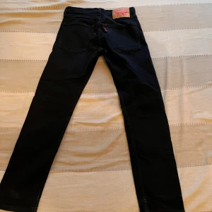 Svarta Levis jeans straight fit - Svarta jeans från Levis med klassisk femficksdesign och raka ben. Byxorna har normal passform och Levis-logga på bakfickan. Perfekta till vardags för en stilren look. Inga skador, Nyskick. Nypris ca. 1100