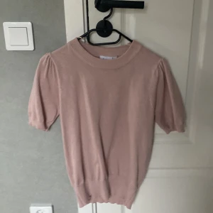Ljusrosa stickad topp från Saint Tropez - Säljer en ljusrosa stickad topp från Saint Tropez i storlek XS. Tröjan har korta puffärmar och bred ribbad kant vid hals, ärmslut och nederkant. Perfekt för vår och sommar!
