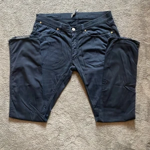 Mörkblå byxor från Acne Studios - Snygga mörkblå byxor från Acne Studios med raka ben. Byxorna har silverfärgade knappar och detaljer samt Acne-logga på bakfickan. Perfekta för en stilren och modern look. De är väldigt svala perfekt för sommaren. Öppen till alla offers‼️‼️