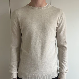 Beige cashmeretröja från John Henric - Säljer en stilren beige tröja från John Henric i mjuk cashmere. Tröjan har rund halsringning, långa ärmar och ribbade muddar. Perfekt för dig som gillar klassisk och enkel stil.