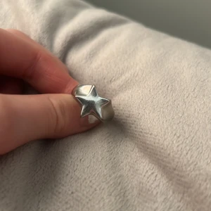 Silverring med stjärndesign - Cool och chunky silverring med en upphöjd stjärna framtill. Perfekt statement-piece för dig som gillar unika smycken. Passar både till vardags och när du vill sticka ut lite extra.