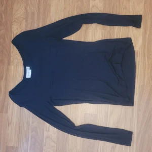 Svart långärmad topp från Vila - En enkel och stilren svart långärmad topp från Gina Tricot. Modellen är figurnära med rund halsringning och mjukt material som passar perfekt till många olika outfits.