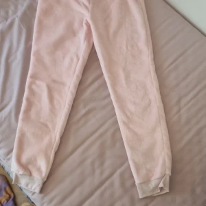 Ljusrosa mjukisbyxor från LCWYOUNG - Supermjuka och sköna ljusrosa mjukisbyxor från KappAhl. Byxorna har resår i midjan och är gjorda i ett fluffigt material som passar perfekt för mysiga dagar hemma.