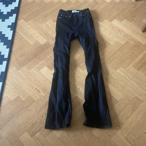 Jeans lager 157 - Säljer ett par svarta flare jeans från 157 i modellen Snake Flare. Byxorna har låg midja och utsvängda ben, samt är i längden short. Perfekta för dig som gillar 70-talsvibbar och vill ha en snygg siluett.