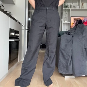 Svarta kostymbyxor - OBS!! ALLA MINA PLAGG GRATIS VID UPPHÄTMNING I RÅCKSTA!!! Säljer ett par svarta kostymbyxor med hög midja och raka, vida ben. Jag är 169 cm lång, så dessa passar bäst på någon som är längre, se längden på benen (uppenbarligen för långa för mig) de är dock för stora för mig på midjan så ta det i beräkning! 